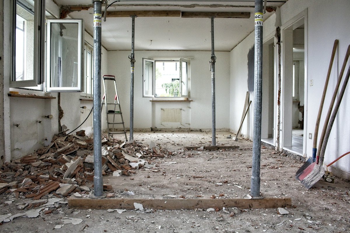 Een kamer in verbouwing, met stalen stempels onder het plafond